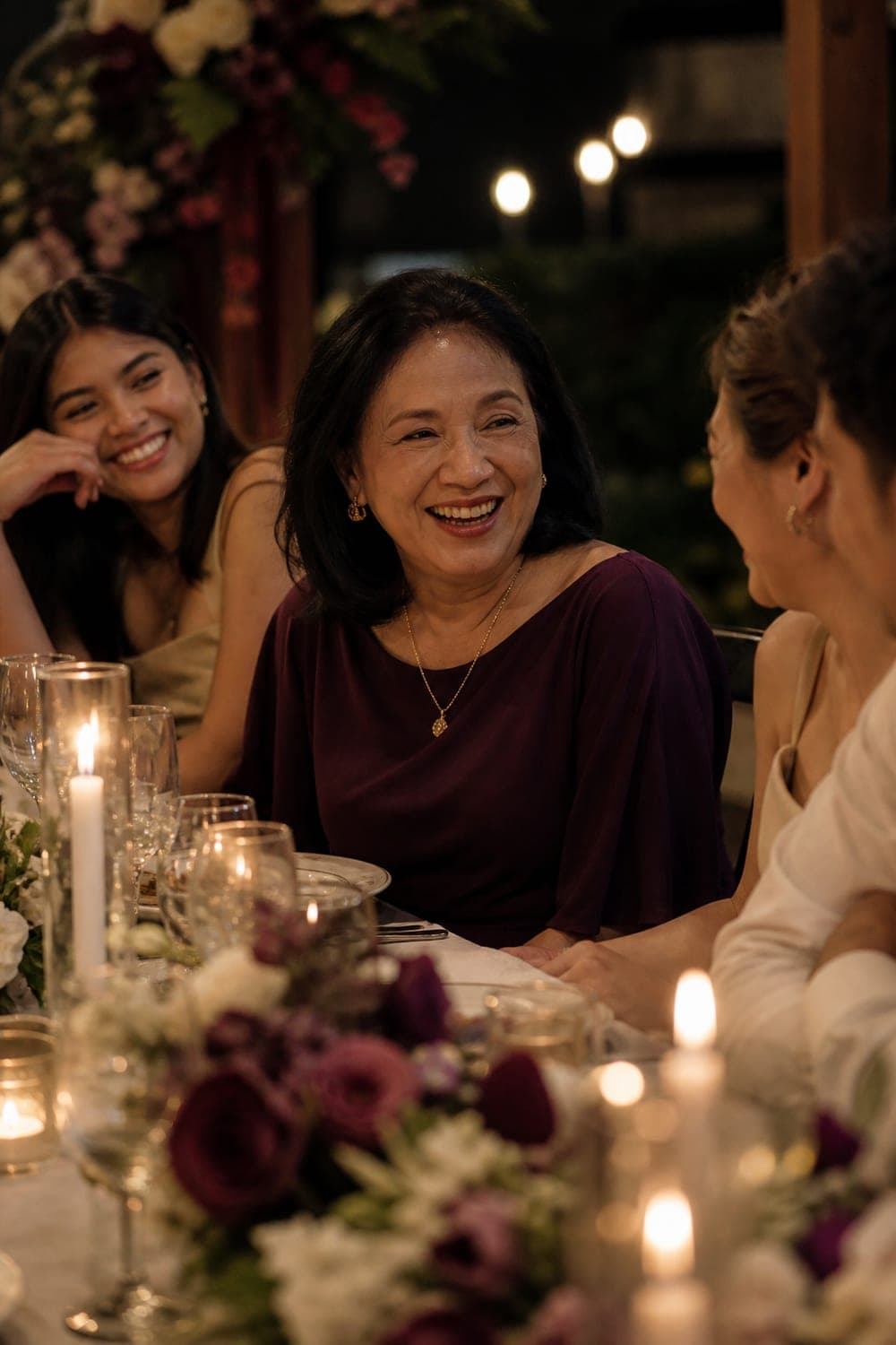 Woman laughing with family at her sixtieth birthday dinner