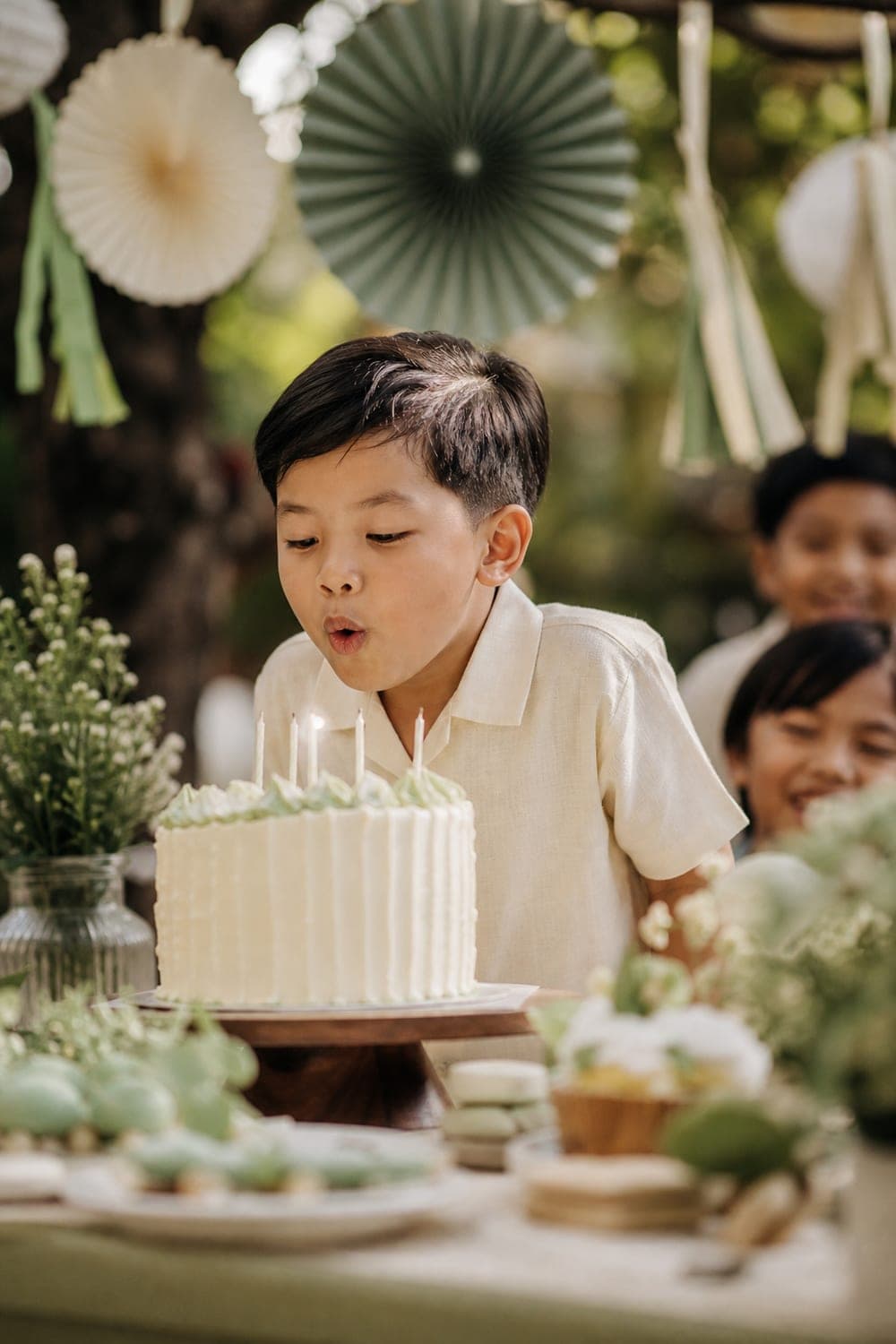 Boy blowing out candles at his seventh birthday party